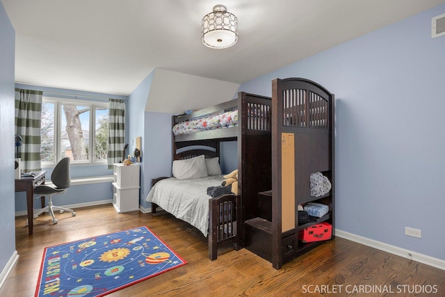 bedroom featuring baseboards, wood finished floors, and visible vents