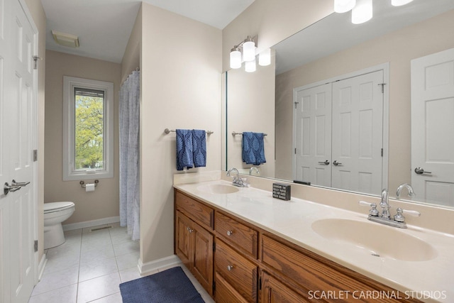 full bathroom featuring a sink, tile patterned flooring, toilet, and double vanity