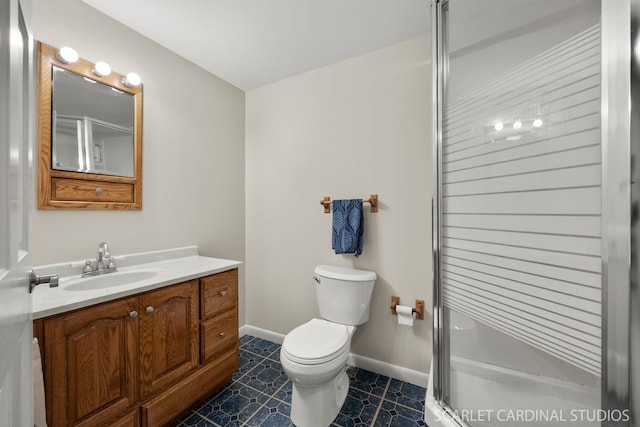 bathroom featuring toilet, baseboards, a shower stall, and vanity