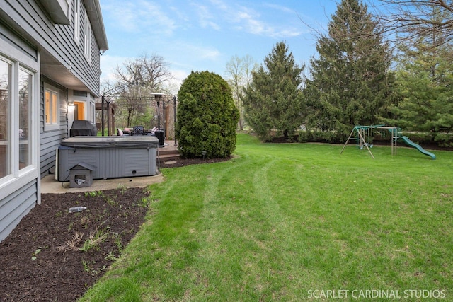 view of yard featuring a playground and a hot tub
