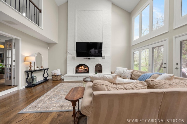 living room with high vaulted ceiling, baseboards, a fireplace, and dark wood finished floors