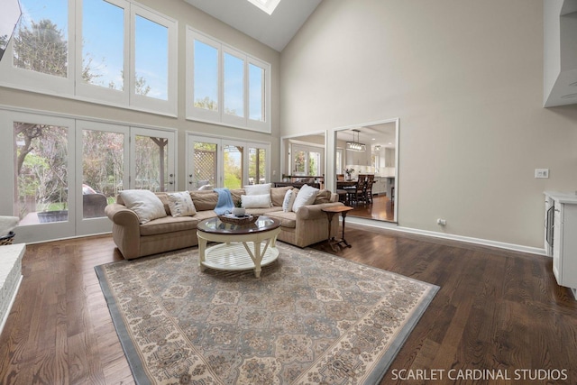 living area with french doors, dark wood-style flooring, high vaulted ceiling, and baseboards