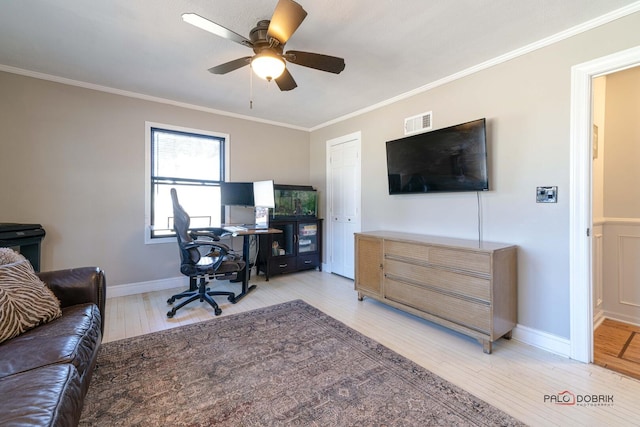 office space with a ceiling fan, visible vents, light wood finished floors, and ornamental molding