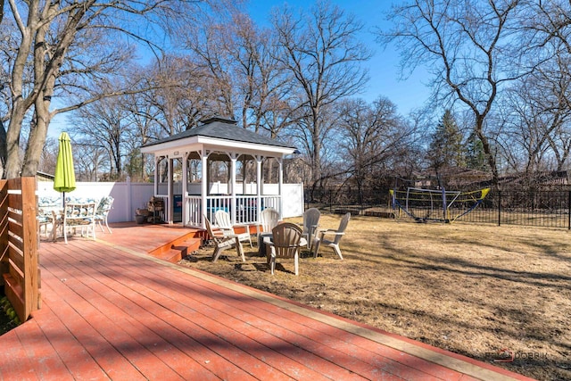 wooden terrace with a gazebo, fence, and an outdoor fire pit