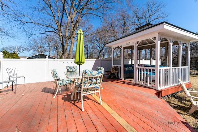 wooden terrace with a gazebo, a fenced backyard, and outdoor dining space