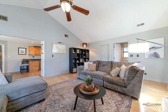 living area with ceiling fan, visible vents, and light wood-type flooring