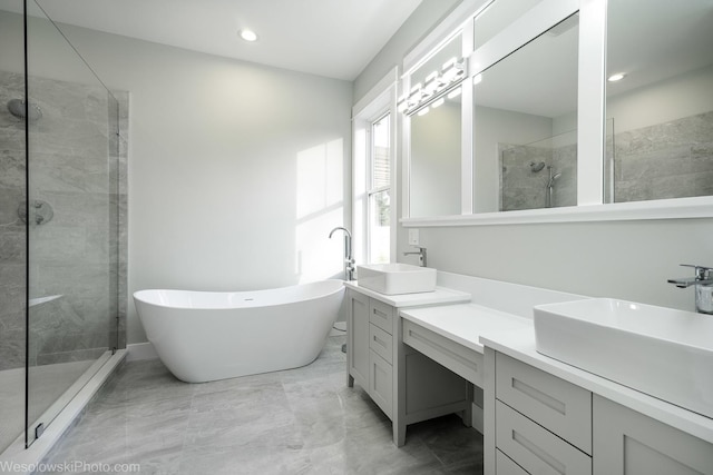 bathroom with marble finish floor, a stall shower, recessed lighting, a soaking tub, and vanity