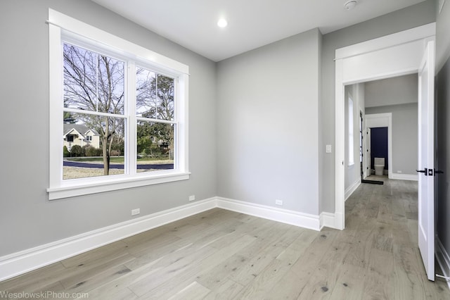 empty room with recessed lighting, baseboards, and light wood finished floors