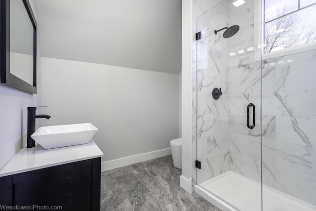 full bathroom featuring a marble finish shower, baseboards, toilet, vaulted ceiling, and vanity