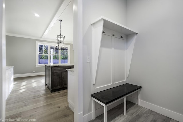 mudroom with light wood-type flooring, baseboards, an inviting chandelier, and beamed ceiling