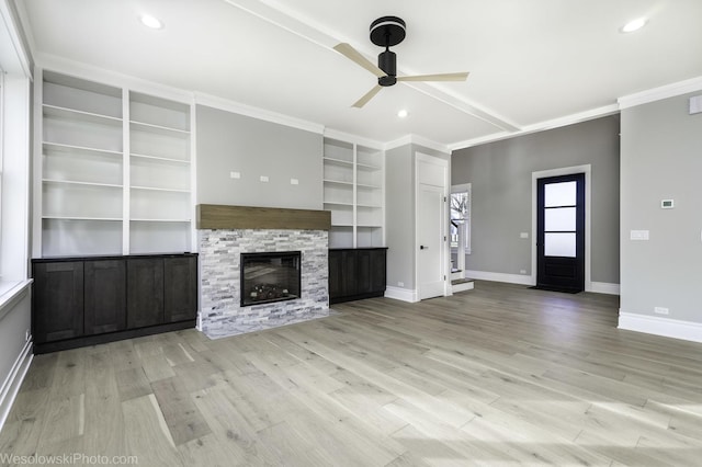 unfurnished living room featuring ceiling fan, baseboards, light wood-style floors, and a glass covered fireplace