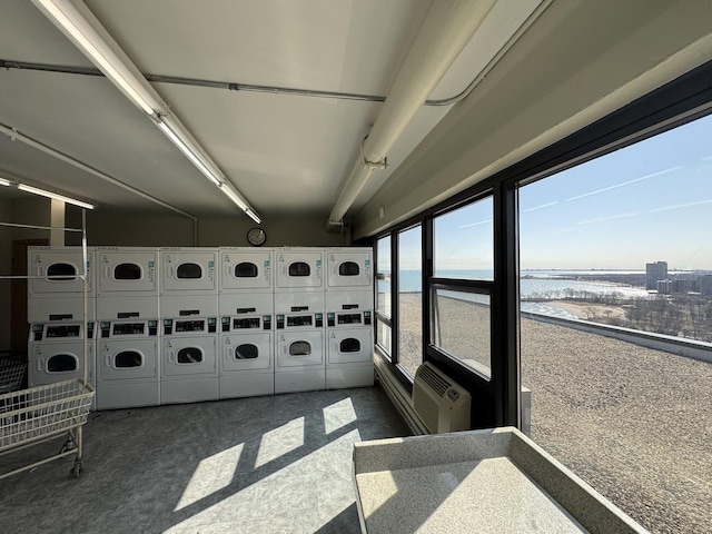 sunroom with an AC wall unit, stacked washing maching and dryer, and separate washer and dryer