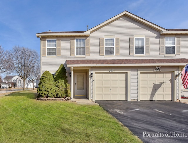 view of property with a garage, driveway, and a front lawn