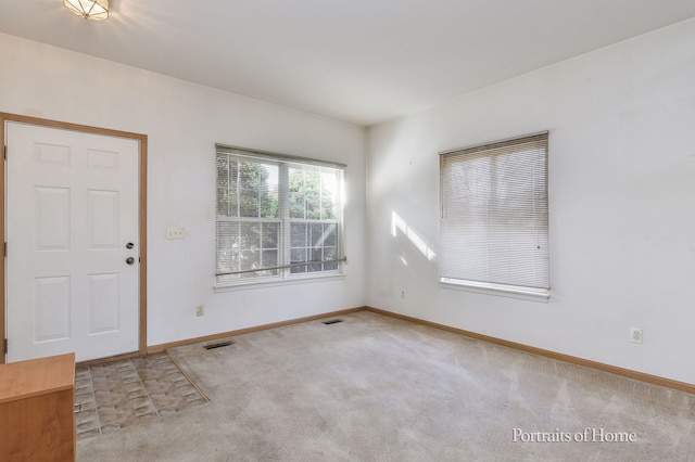 foyer entrance featuring carpet flooring, baseboards, and visible vents