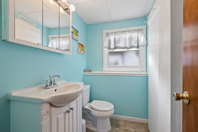 bathroom featuring toilet, vanity, and a paneled ceiling