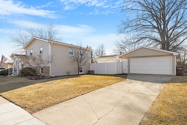 view of property exterior with central air condition unit, a detached garage, a yard, and fence