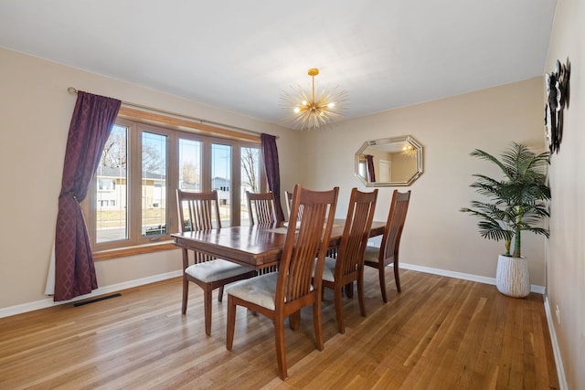 dining area with visible vents, baseboards, a notable chandelier, and light wood finished floors