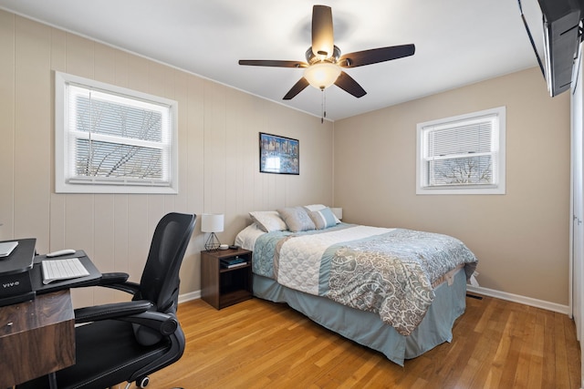 bedroom featuring baseboards, light wood-style floors, and a ceiling fan