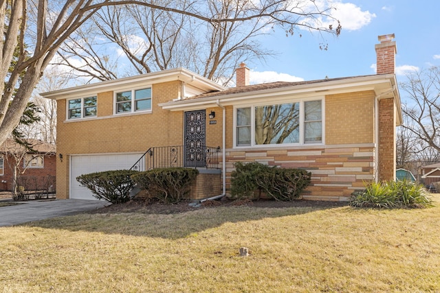 split level home with brick siding, aphalt driveway, a front yard, a chimney, and a garage