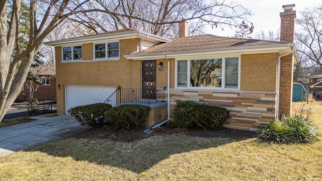 split level home featuring a front lawn, concrete driveway, an attached garage, brick siding, and a chimney