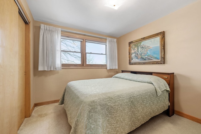 bedroom with a closet, baseboards, and carpet