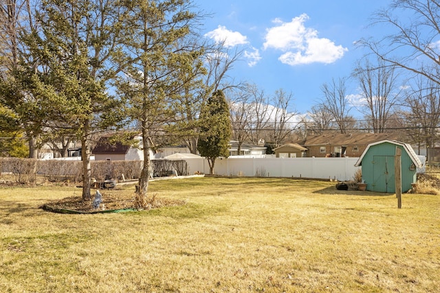 view of yard with an outbuilding, a storage shed, and fence