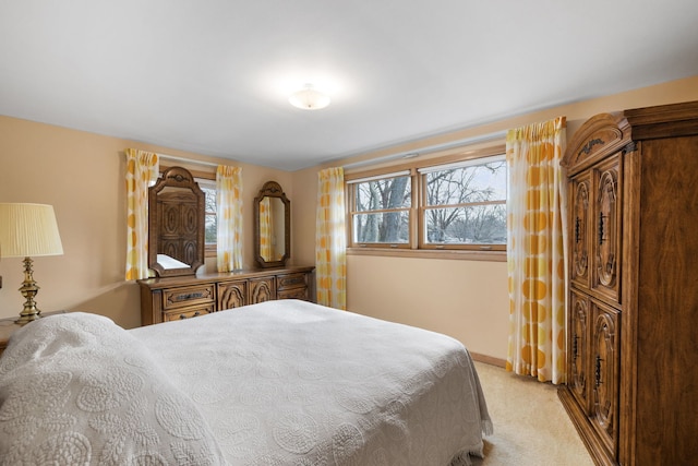 bedroom with baseboards and light carpet