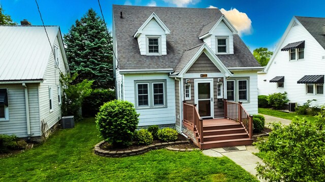 319 S 3rd St, Watseka, IL 60970 - new england style home with a front lawn, central air condition unit, and a shingled roof