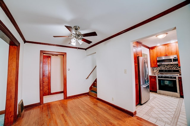 319 S 3rd St, Watseka, IL 60970 - kitchen with appliances with stainless steel finishes, light wood-type flooring, decorative backsplash, a ceiling fan, and baseboards