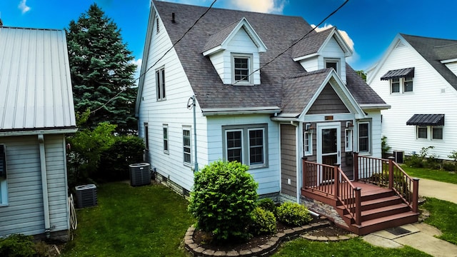 319 S 3rd St, Watseka, IL 60970 - view of front of house with cooling unit, a front yard, and a shingled roof