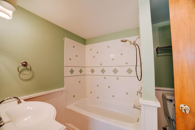 319 S 3rd St, Watseka, IL 60970 - bathroom with a sink, a wainscoted wall, shower / washtub combination, and toilet