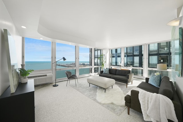 carpeted living area featuring recessed lighting, floor to ceiling windows, and a water view