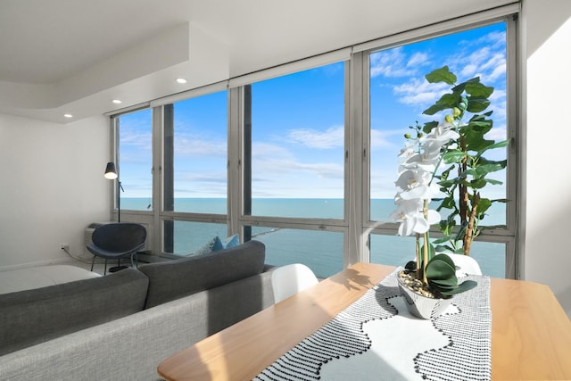 dining room featuring a wall of windows, a water view, and recessed lighting