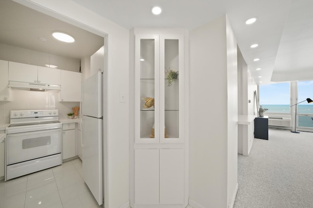 kitchen featuring under cabinet range hood, white appliances, recessed lighting, and light countertops