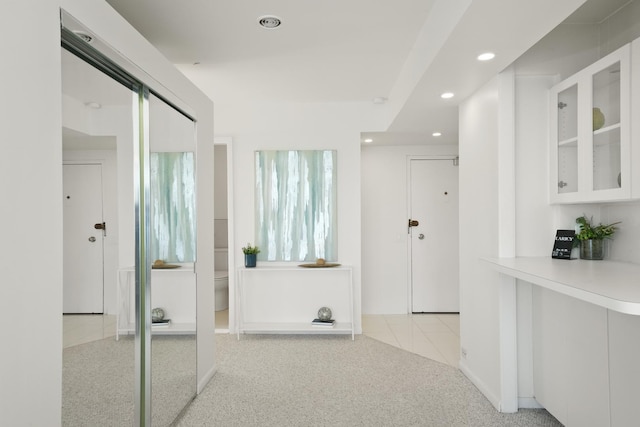 hall with light carpet, light tile patterned floors, and recessed lighting