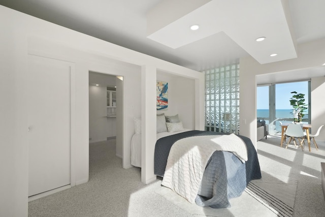 carpeted bedroom with recessed lighting, a water view, and access to outside