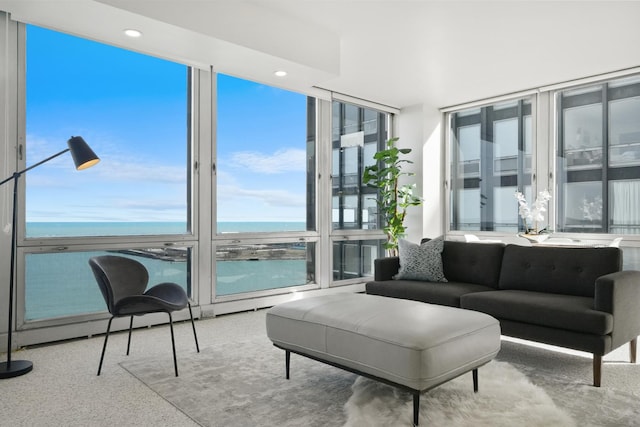 living area with a wall of windows, a water view, a wealth of natural light, and recessed lighting