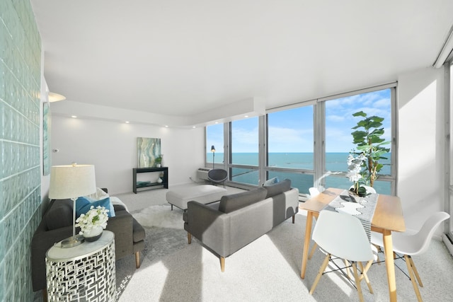 carpeted living room with floor to ceiling windows and a water view