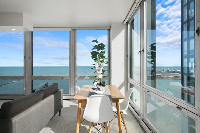 sunroom / solarium with a baseboard heating unit and a water view