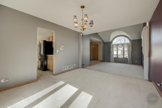 unfurnished room featuring vaulted ceiling, baseboards, a chandelier, and light carpet