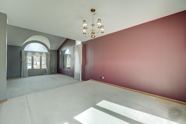 spare room featuring vaulted ceiling, a notable chandelier, baseboards, and carpet floors