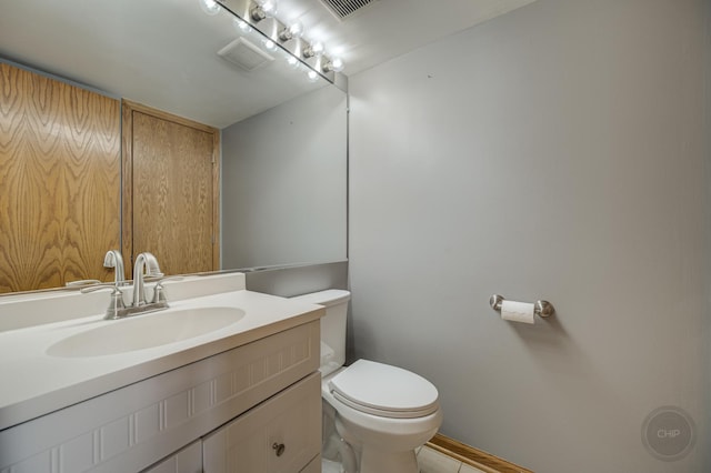 bathroom featuring visible vents, toilet, and vanity