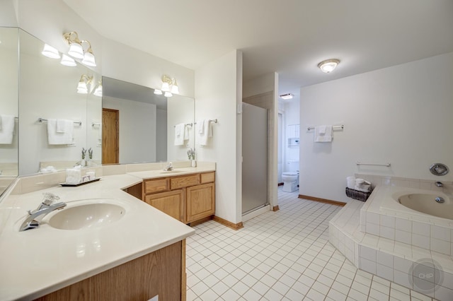 bathroom featuring tile patterned floors, a garden tub, a shower stall, baseboards, and vanity