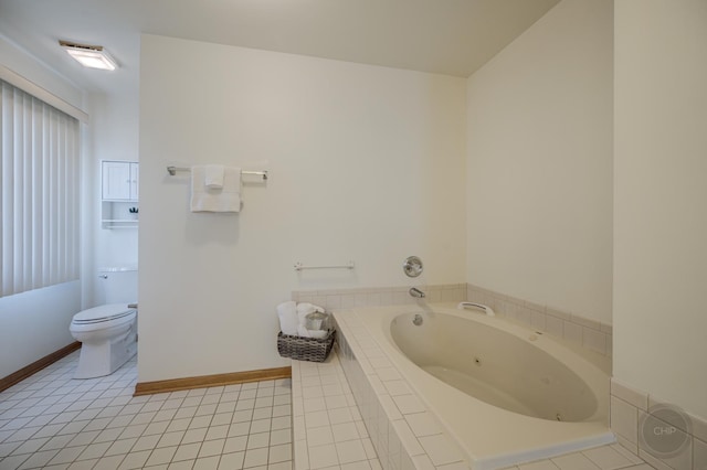 bathroom featuring tile patterned flooring, toilet, baseboards, and a whirlpool tub