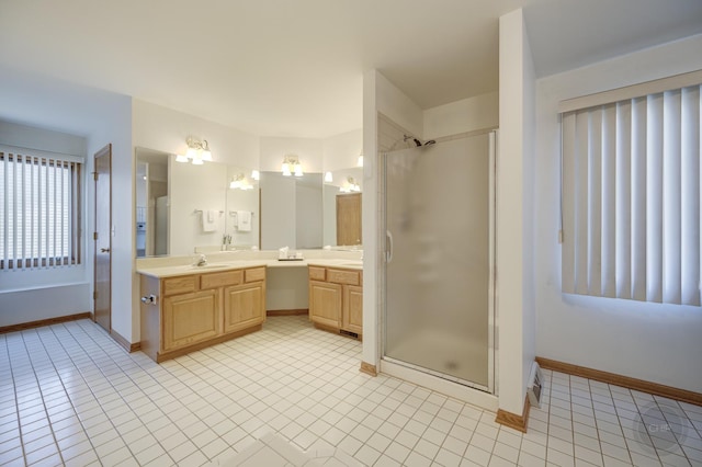 full bath featuring vanity, tile patterned floors, baseboards, and a stall shower