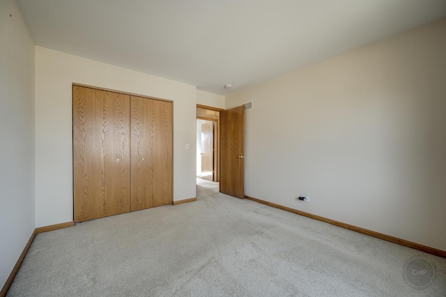 unfurnished bedroom with visible vents, baseboards, carpet, and a closet