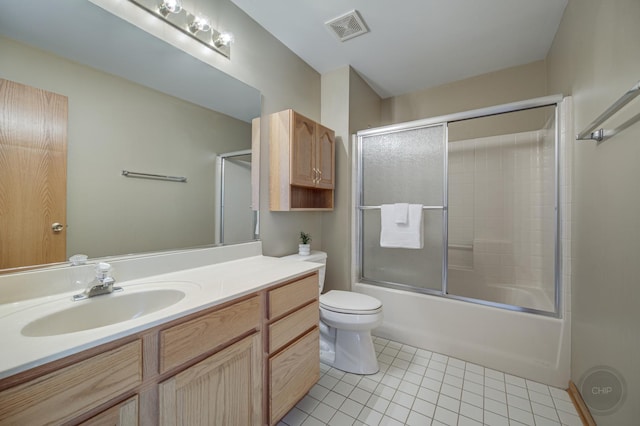 full bathroom with vanity, visible vents, shower / bath combination with glass door, tile patterned floors, and toilet