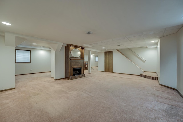 unfurnished living room featuring stairway, visible vents, baseboards, recessed lighting, and light colored carpet