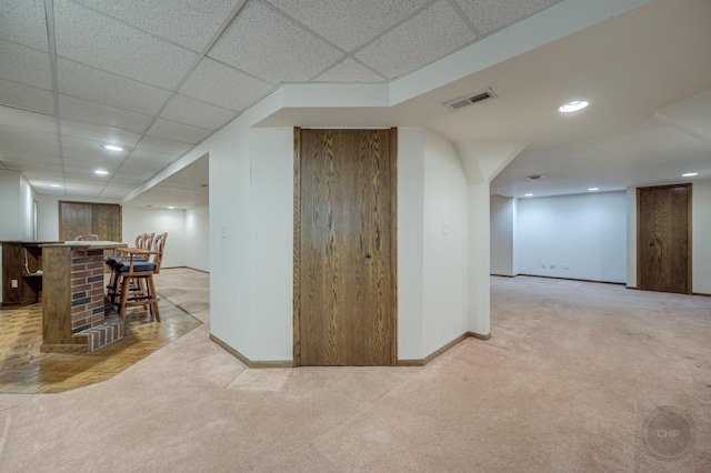 interior space featuring visible vents, baseboards, light carpet, bar, and recessed lighting