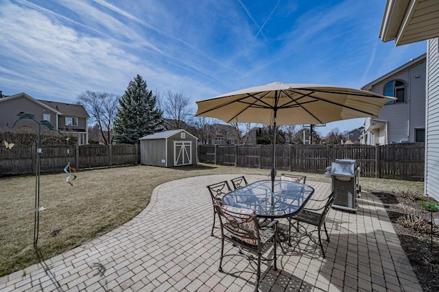 view of patio featuring an outbuilding, a fenced backyard, a storage shed, and outdoor dining space